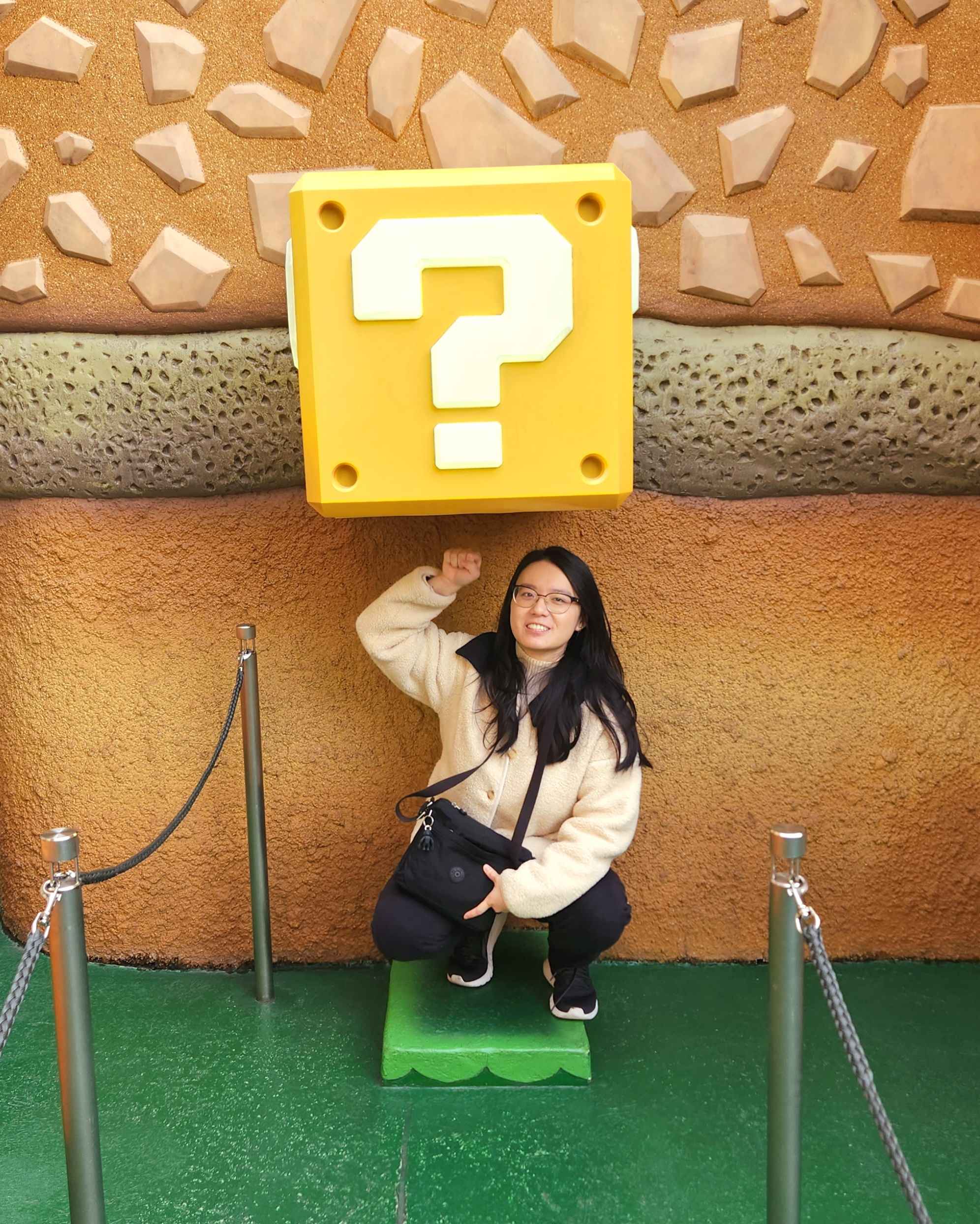 Sabrina Paramitha at USJ posing underneath a block from the Super Mario series